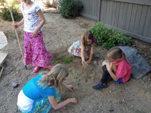 little girls planting a garden with weeds